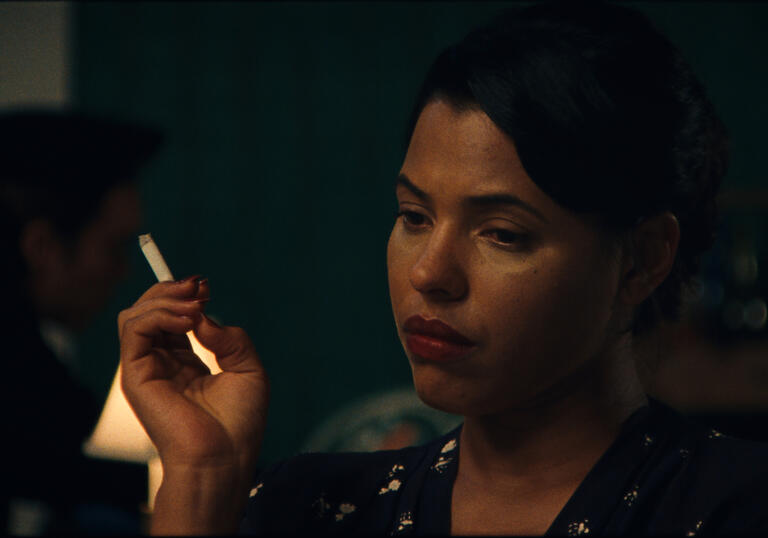 A woman sadly smokes a cigarette