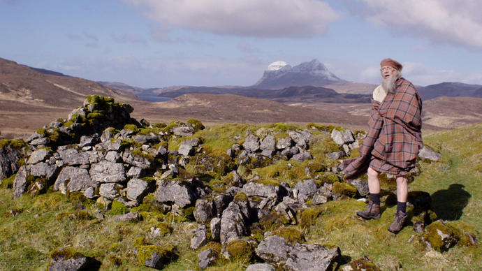 Man in kilt standing on a hill