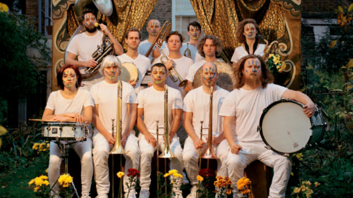 Hackney Colliery Band sat in two lines with their instruments