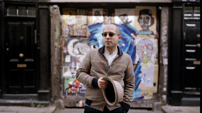 Mahan Esfahani in front of a graffiti wall