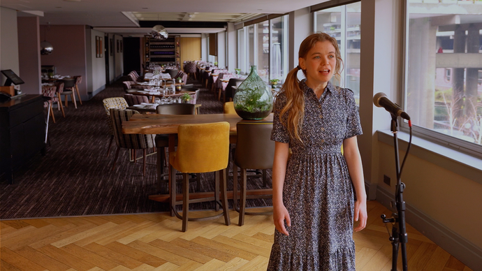 Héloïse Werner singing in front of the tables in Osteria