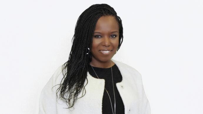 Nadine Benjamin smiling in front of a white background