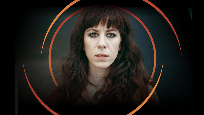 Missy Mazzoli looking at the camera, with circular orange swirls around her head