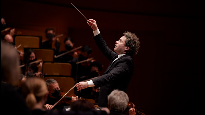 A side-on shot of Gustavo Dudamel conducting