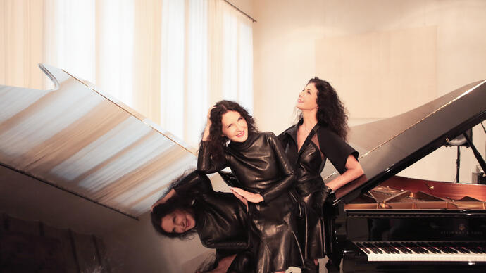 Katia and Marielle Labèque posing with two grand pianos