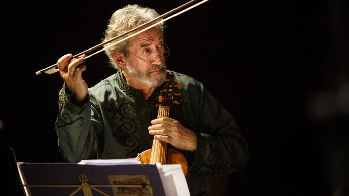 Jordi Savall holding a treble viol, directing with his bow