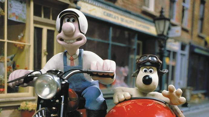 Wallace and Gromit drive around on a motorbike. 