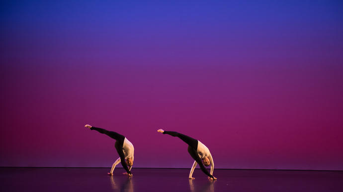 A coloured image showing two dancers from the Michael Clark Company against a blue and pink background