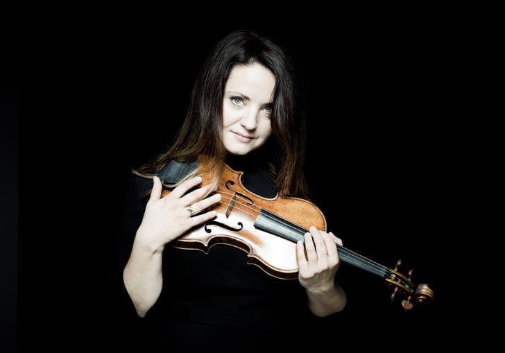 Baiba Skride with violin dark background