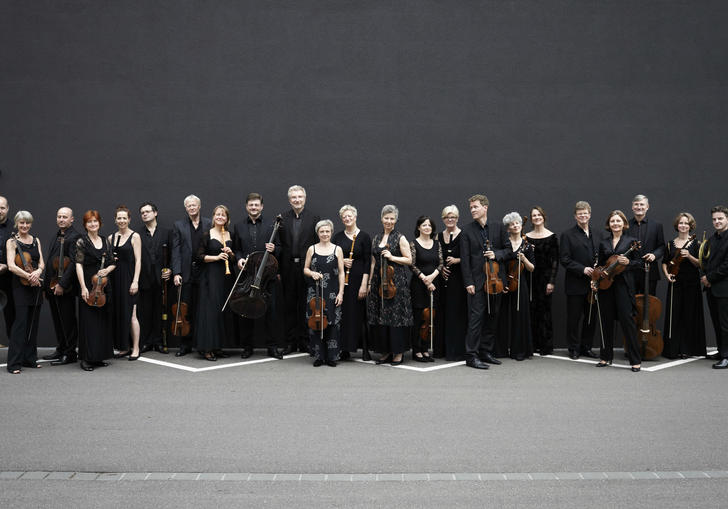 Freiburg Baroque Orchestra standing black wall