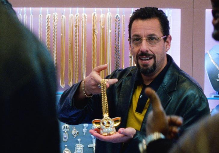 Adam Sandler as a jewellery dealer holding up a gold chain