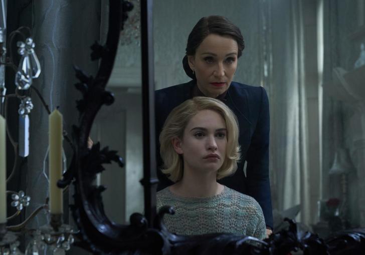 Lily James (playing Rebecca) looking into a mirror with Kristen Scott Thomas standing over her