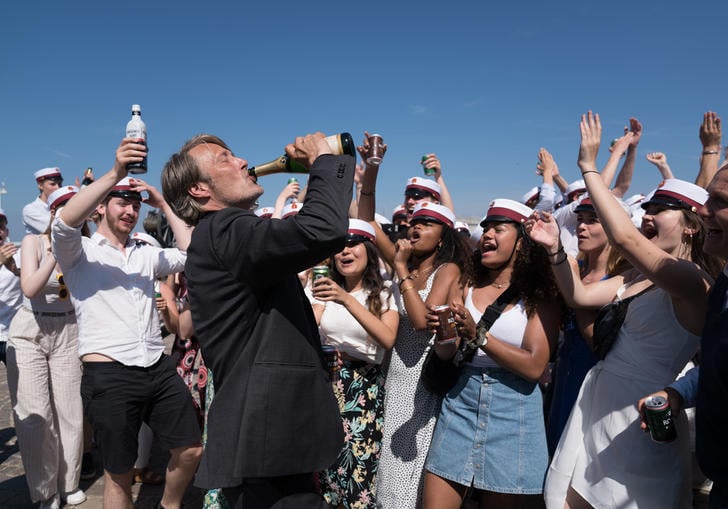 Man stands in a circle of students drinking