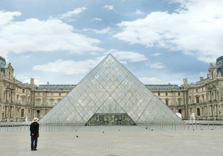 The director stands in front of the Louvre