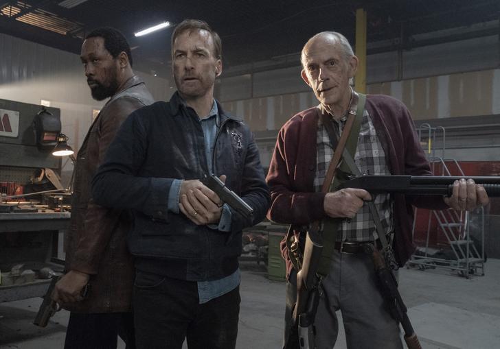 Bob Odenkirk and Christopher Lloyd stand in a striking pose holding guns