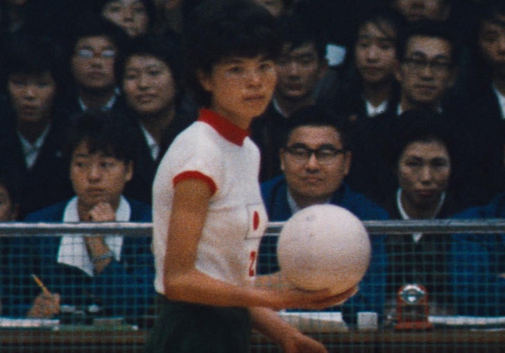 Volleyball player holding the ball in front of the crowd