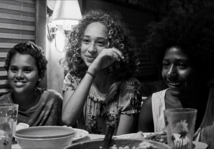 Nico Rockwell, Lana Rockwell and Jabari Watkins sit next to each other at a dinner table in a b&w image from Sweet Thing