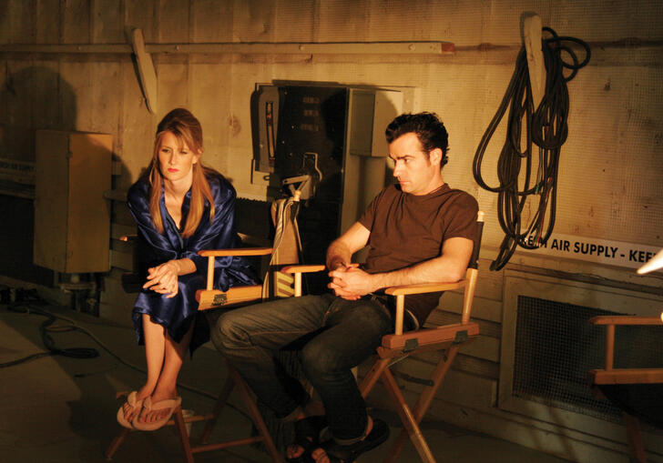 An actor and director sit on a dark set in a still from Inland Empire