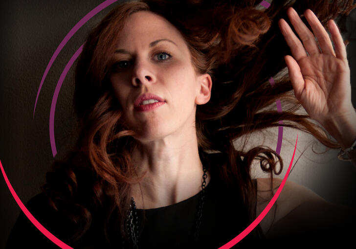 Missy Mazzoli with her hand up by her face and her hair blowing in the wind, with circular purple and pink swirls around her head