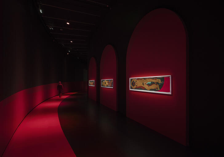 The Curve gallery in red lighting showing drawings by Soufiane Ababri on the walls