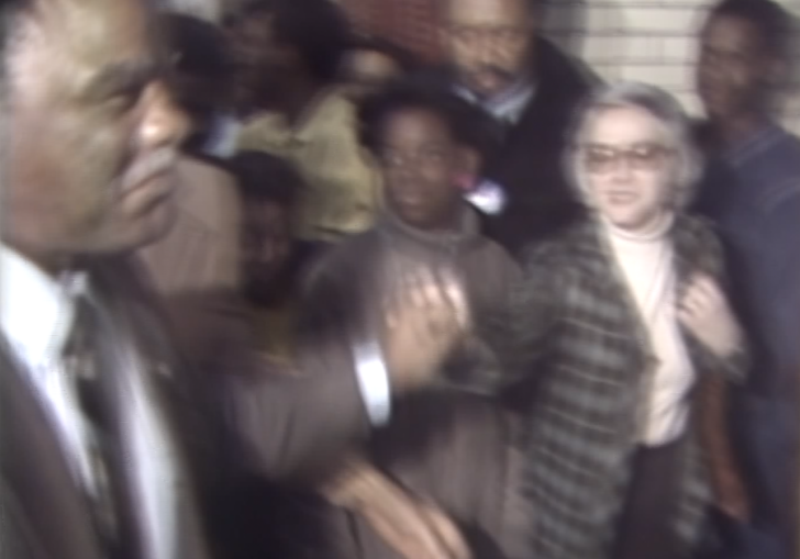 A group of men in suits run forward.