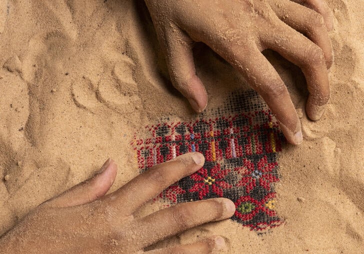 A pair of hands touch a piece of fabric