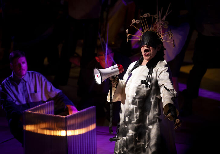 A woman sings into a megaphone