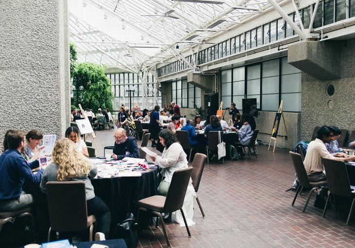 people sitting on tables on conservatory terrace in a workshop