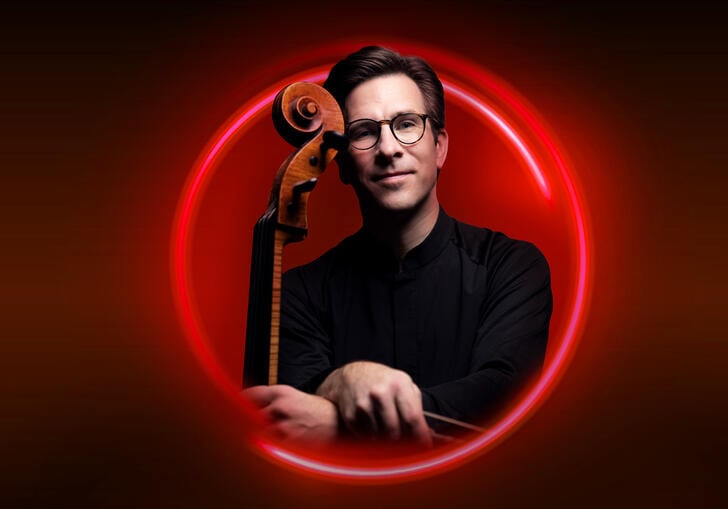 An image of Guy Johnston surrounded by a red circle against a red backdrop