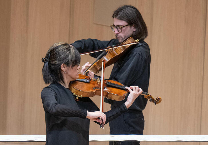 two violinist playing the violin diagonally from each other
