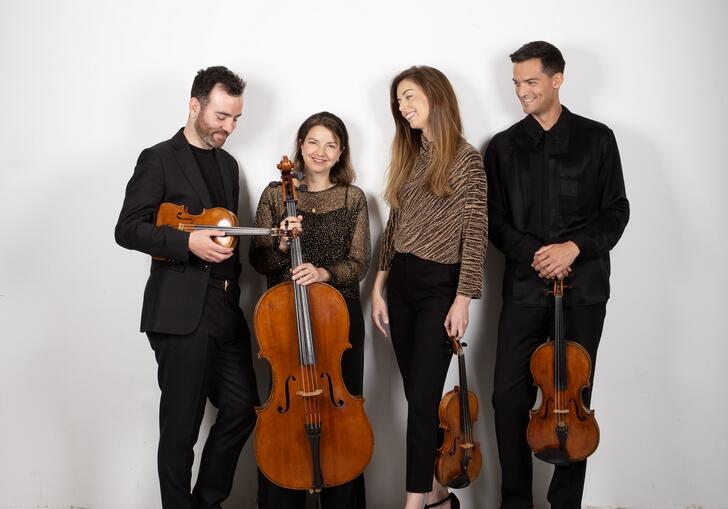 Solem Quartet group photo (from left to right) with William Newell holding a violin Stephanie Tress holding a cello, Amy Tress holding a violin and Stephen Upshaw holding a violin