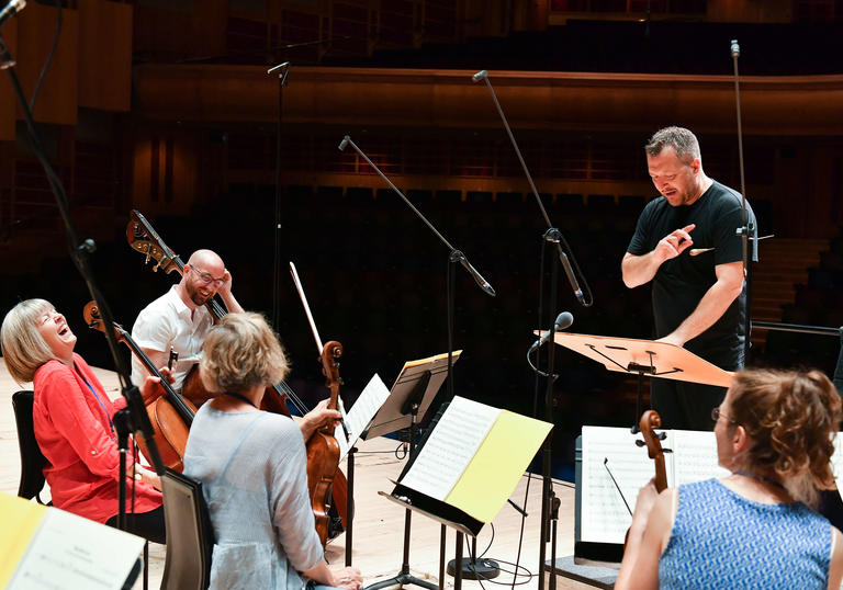 Britten Sinfonia rehersing with conductor laughing