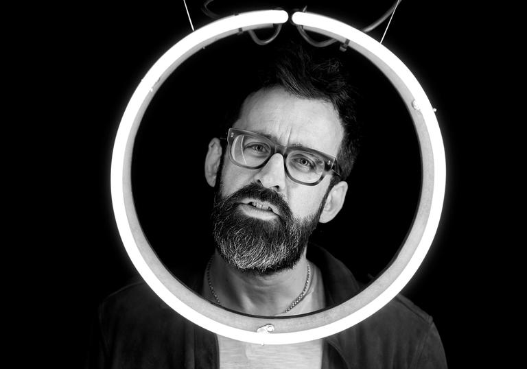 Neil Cowley posing with a circular light