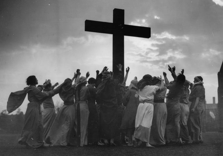 Group of people surrounding a cross