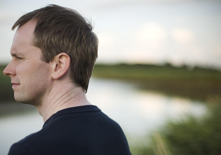 Pianist Steven Osborne stands by a river