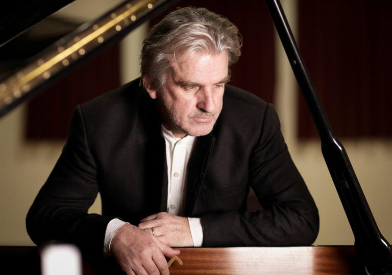 Pianist Barry Douglas stands by a piano