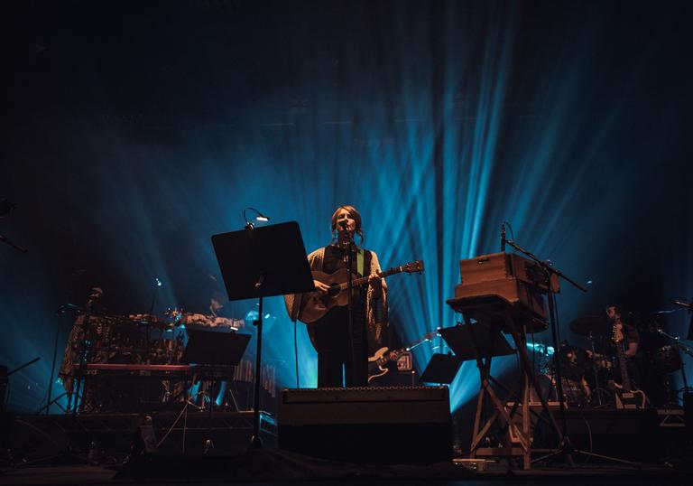 Karine Polwart singing and playing an acoustic guitar on stage