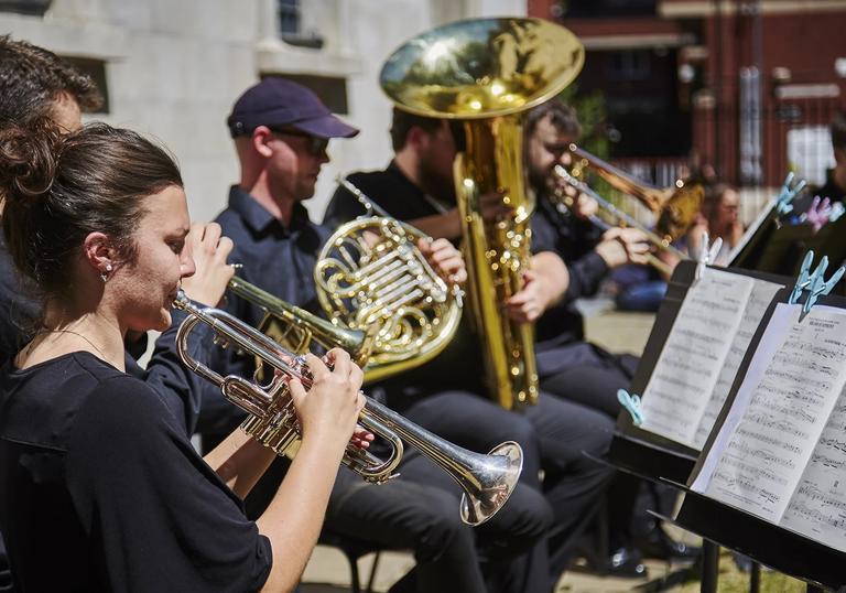 Guildhall brass musicians performing outside LSO St Luke's