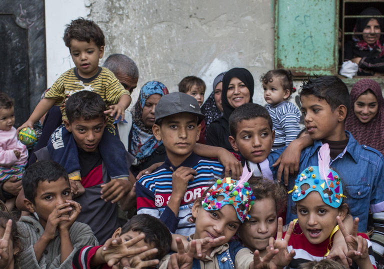 group of children and young people huddled together looking at the camera