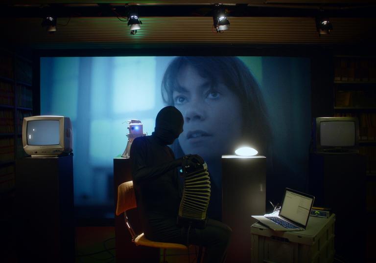 dark room with a screen in it with a woman's face on it