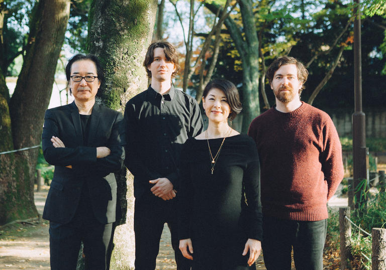 Spencer Doran and Ryan Carlile (Visible Cloaks) with Yoshio Ojima and Satsuki Shibano standing in a park