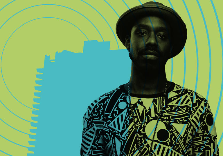 Shabaka Hutchings with a silhouette of the Barbican behind him