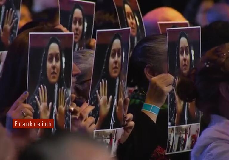 Women hold up the picture of a woman