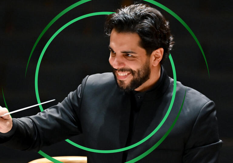 Domingo Hindoyan conducting, with green circular swirls around him