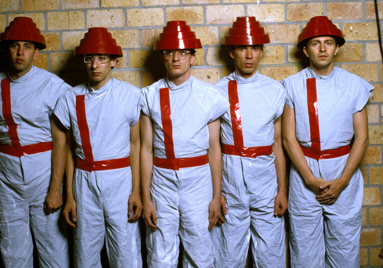 Band dressed in white short-sleeved jumpsuits and red hats