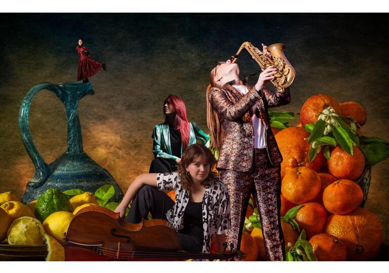 Jess Gillam playing the saxophone in front of a pile of giant oranges