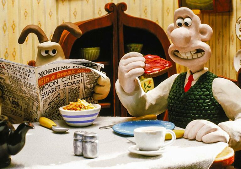 Wallace and Gromit sit at the table having breakfast - Gromit looks angry.