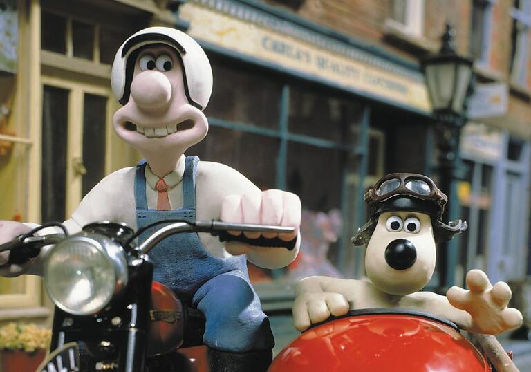 Wallace and Gromit drive around on a motorbike. 