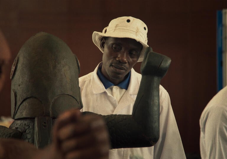 A person looks at an African artifact. 