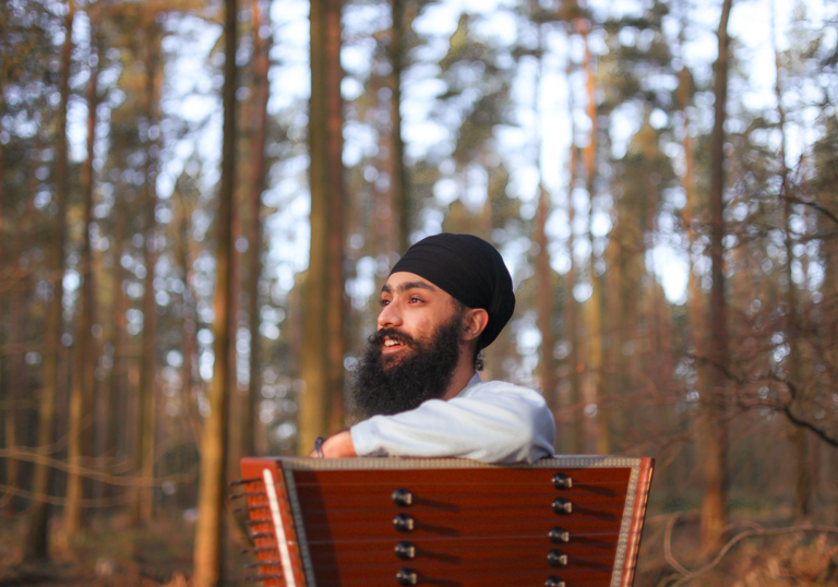 Eeshar Singh sits on a chair in the woods